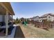Fenced backyard featuring a playset, grassy area, and mature trees at 7435 Ansley Park Way, Cumming, GA 30028