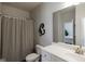 Bathroom featuring a toilet, sink, mirror, and striped shower curtain, and neutral paint at 7435 Ansley Park Way, Cumming, GA 30028