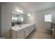 Bright bathroom with double sinks, a large mirror, tiled floors, and a window with blinds at 7435 Ansley Park Way, Cumming, GA 30028