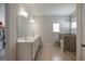 Bathroom featuring double sinks, tiled floors, glass shower, and a window with blinds at 7435 Ansley Park Way, Cumming, GA 30028