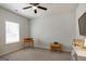 Bright bedroom featuring a ceiling fan, window with blinds, and desk area for versatile use at 7435 Ansley Park Way, Cumming, GA 30028