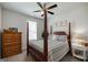 Bedroom featuring a four-poster bed, ceiling fan, and dresser with neutral paint at 7435 Ansley Park Way, Cumming, GA 30028