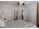 Bedroom featuring a four-poster bed, ceiling fan, with ensuite bathroom, neutral paint at 7435 Ansley Park Way, Cumming, GA 30028