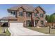 Charming two-story brick home with a manicured lawn and a spacious driveway at 7435 Ansley Park Way, Cumming, GA 30028