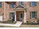 Close-up of front entrance with detailed brickwork, welcoming porch, and landscaped garden at 7435 Ansley Park Way, Cumming, GA 30028