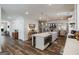 Open concept kitchen with island, white cabinets, stainless steel appliances, and hardwood floors at 7435 Ansley Park Way, Cumming, GA 30028
