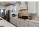 Gourmet kitchen with white cabinets, stainless steel appliances, and a subway tile backsplash at 7435 Ansley Park Way, Cumming, GA 30028