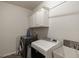 Functional laundry room with washer, dryer, cabinets, and utility sink at 7435 Ansley Park Way, Cumming, GA 30028