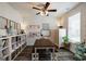 Bright room featuring shelving, a ceiling fan, and a long dark wooden table with light wooden legs and benches at 7435 Ansley Park Way, Cumming, GA 30028