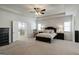 Main bedroom with tray ceiling, ceiling fan, and an en-suite bathroom at 7435 Ansley Park Way, Cumming, GA 30028