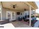 Covered patio with ceiling fans, comfortable seating, and outdoor grill at 7435 Ansley Park Way, Cumming, GA 30028