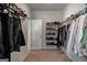 Walk-in closet providing ample storage with shelving, hanging rods, a carpeted floor and entry door at 7435 Ansley Park Way, Cumming, GA 30028