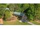 An aerial view of a charming one-story house with a green metal roof surrounded by lush trees and a well-manicured lawn at 1256 Horsley Mill Rd, Carrollton, GA 30116