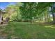 Expansive green backyard featuring lush grass and mature trees, creating a serene outdoor space at 1256 Horsley Mill Rd, Carrollton, GA 30116