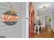 Bright entryway with a red front door, a decorative sign, and a glimpse into a neatly decorated interior at 1256 Horsley Mill Rd, Carrollton, GA 30116