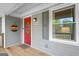 Close-up of a red front door with a glass insert, complemented by gray siding and a welcoming porch decor at 1256 Horsley Mill Rd, Carrollton, GA 30116