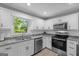 This kitchen features white cabinets, stainless appliances, granite counters and a window at 1256 Horsley Mill Rd, Carrollton, GA 30116