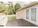 View of the outdoor wood deck with white railing and double doors of this cozy, single-Gathering home at 15 Pine Run Rd, Carrollton, GA 30116