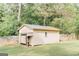 A charming storage shed sits in the backyard with a covered area and attached wooden fence at 15 Pine Run Rd, Carrollton, GA 30116