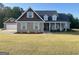 Charming brick home features an attached garage, inviting front porch with rocking chairs, and a well-manicured lawn at 30 Scouts Ridge Dr, Covington, GA 30016