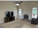 Bright living room with fireplace, ceiling fan, and a large TV at 30 Scouts Ridge Dr, Covington, GA 30016