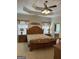 Well-lit main bedroom with tray ceilings, a large bed, and access to the en-suite bathroom at 30 Scouts Ridge Dr, Covington, GA 30016