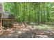 This backyard offers a raised porch and plenty of green space surrounded by tall trees for privacy at 146 Highland Cir, Mcdonough, GA 30253