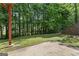 Spacious backyard with lush greenery, a concrete patio, and retaining wall at 462 Chase Marion Way, Mcdonough, GA 30253