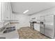 Bright kitchen showcasing tile flooring, white cabinets, and modern stainless steel appliances at 462 Chase Marion Way, Mcdonough, GA 30253