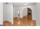 Open-concept living room with hardwood floors, stone fireplace, and archways that lead to other rooms at 462 Chase Marion Way, Mcdonough, GA 30253