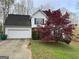 Charming home with an attached garage and a beautifully landscaped front yard featuring a vibrant red Japanese maple tree at 602 Springharbor Dr, Woodstock, GA 30188