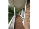 Inviting front porch featuring stone accents, wood flooring, and white railing overlooking the lush greenery at 22 Shea Ct, Douglasville, GA 30134