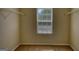 Walk-in closet with carpeted floors and two shelves, illuminated by a window at 11224 Aliyah Dr, Hampton, GA 30228