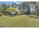 Grassy backyard featuring mature trees, lush landscaping, and a serene atmosphere at 105 Suffolk Pl, Fayetteville, GA 30215
