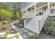 Side view of a beautiful home with white siding, complemented by stone pathways and manicured landscaping at 105 Suffolk Pl, Fayetteville, GA 30215