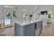 Bright kitchen featuring a gray island, hardwood floors, and doors leading to a pool at 105 Suffolk Pl, Fayetteville, GA 30215