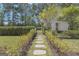 Charming pathway leads to a beautifully landscaped yard with mature trees and lush greenery at 105 Suffolk Pl, Fayetteville, GA 30215