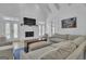 Bright living room featuring a fireplace, large sectional sofa, and access to outdoor space through double doors at 105 Suffolk Pl, Fayetteville, GA 30215