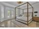 Comfortable bedroom with a four-poster bed, white walls, and access to the outdoors through French doors at 105 Suffolk Pl, Fayetteville, GA 30215