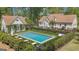 Aerial view of backyard in-ground swimming pool and pool house surrounded by lush landscaping and seating at 105 Suffolk Pl, Fayetteville, GA 30215