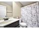 Simple bathroom featuring single sink vanity and a toilet with a decorative shower curtain at 9929 Musket Ridge Cir, Jonesboro, GA 30238
