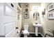 Charming half-bathroom featuring a pedestal sink, tasteful decor, and dark wood flooring at 9929 Musket Ridge Cir, Jonesboro, GA 30238