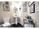 Cozy powder room with a pedestal sink, wall art, and dark wood flooring at 9929 Musket Ridge Cir, Jonesboro, GA 30238
