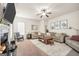 Comfortable living room with a fireplace, sofas, natural light, and a ceiling fan at 9929 Musket Ridge Cir, Jonesboro, GA 30238