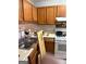 Galley kitchen with wood cabinetry, stainless steel sink, and white appliances at 3464 Kingswood Trl, Decatur, GA 30034