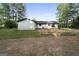 The backyard shows the layout of the house, large trees, and patchy ground at 389 Rosser Rd, Mcdonough, GA 30252