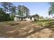 The rear of the house is seen from the backyard, surrounded by mature trees at 389 Rosser Rd, Mcdonough, GA 30252