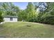 Open backyard with a fire pit, sparse trees, and an adjacent building visible at 389 Rosser Rd, Mcdonough, GA 30252