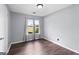 A well-lit bedroom featuring a window, gray walls, and dark wood-look flooring at 389 Rosser Rd, Mcdonough, GA 30252