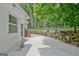 A relaxing backyard with a concrete patio, a rock wall, and access to a peaceful wooded area at 135 Adams Park Dr, Fayetteville, GA 30214